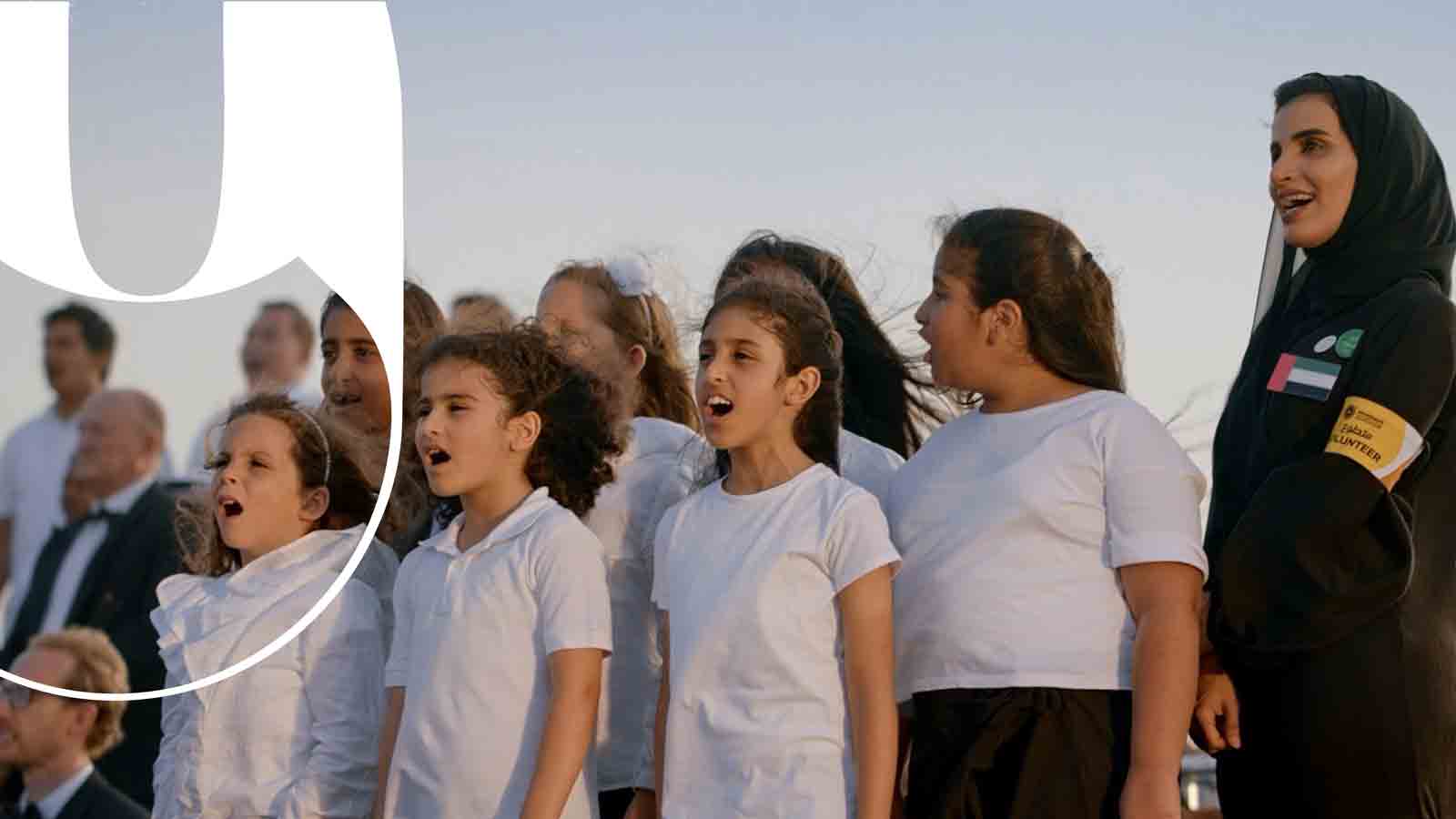 A group of children happily singing as part of a concert in the desert