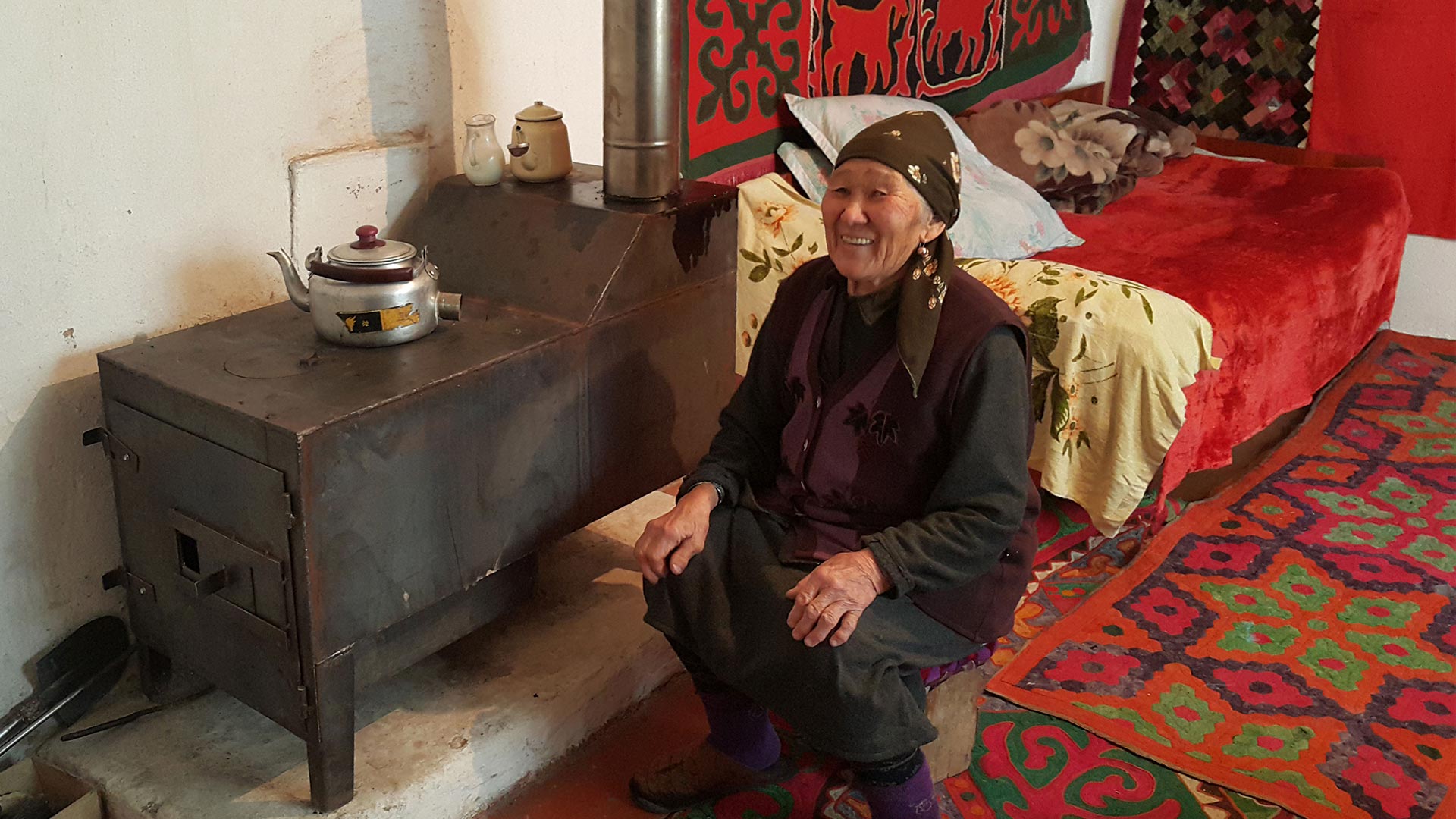 Old Kyrgyz woman sitting down smiling