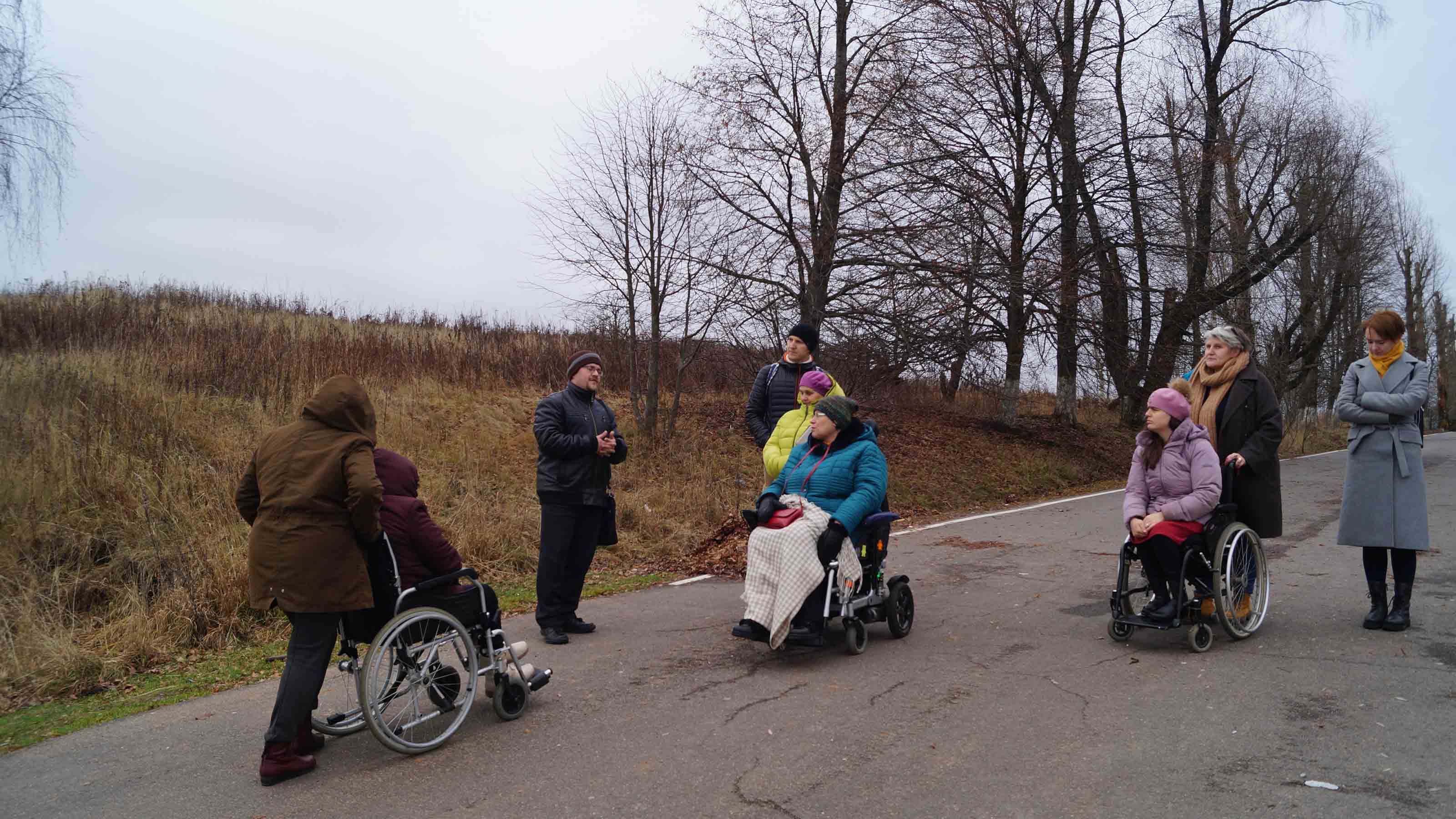 People on wheelchair talking outdoors