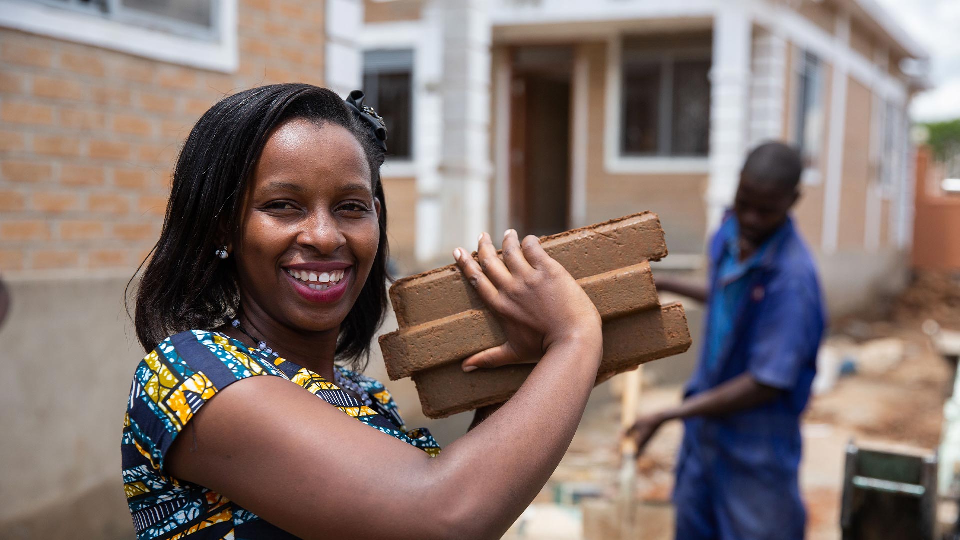 Woman carrying a brick smiling