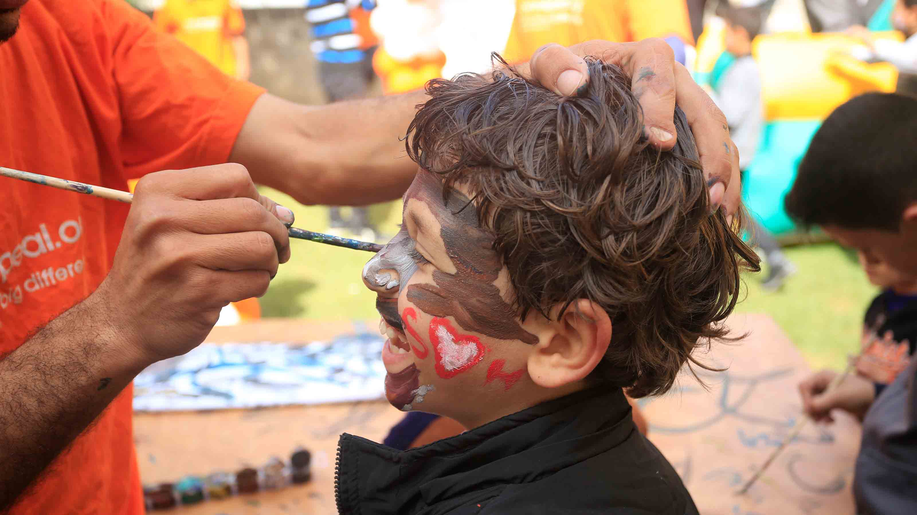 Smiling boy being face-painted