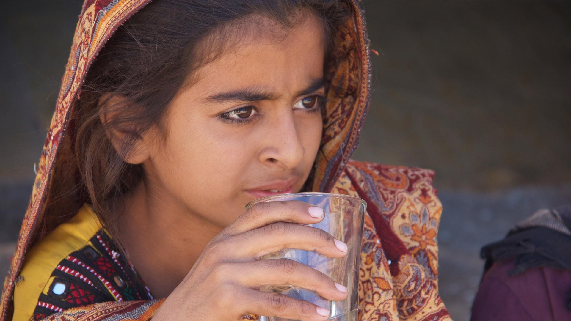 A Pakistani girl holding a glass of water